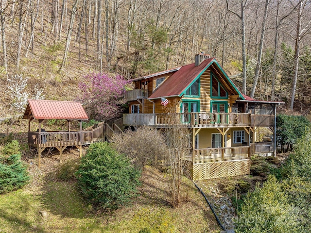 rear view of house featuring a gazebo and a wooden deck