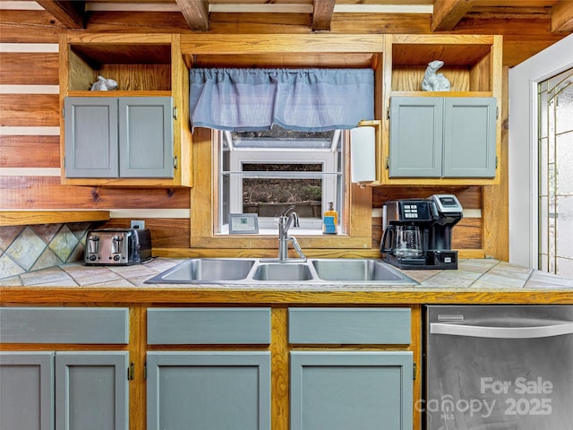 kitchen featuring stainless steel dishwasher, tile countertops, sink, and backsplash