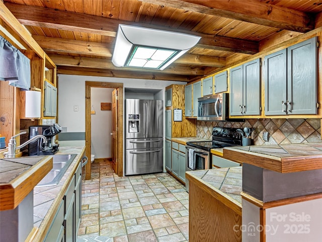 kitchen featuring tasteful backsplash, beamed ceiling, sink, wood ceiling, and stainless steel appliances