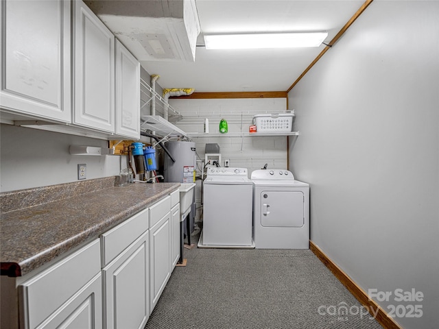 clothes washing area featuring dark carpet, cabinets, and washing machine and clothes dryer