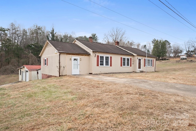 ranch-style house with a front lawn and a shed