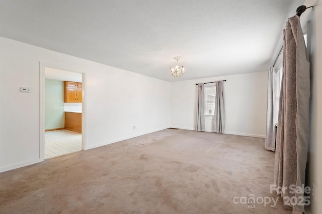 empty room featuring a chandelier and carpet