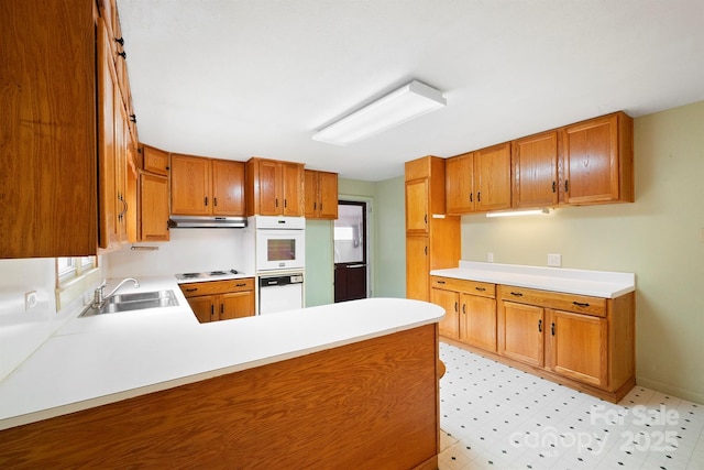 kitchen with sink, white appliances, a wealth of natural light, and kitchen peninsula