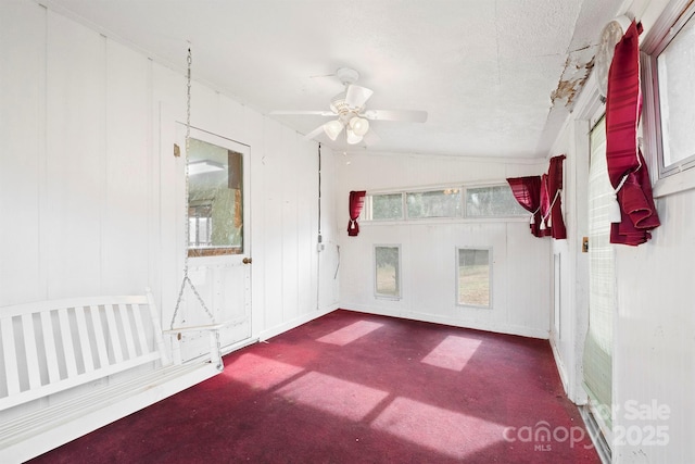 carpeted spare room featuring lofted ceiling, ceiling fan, and a textured ceiling