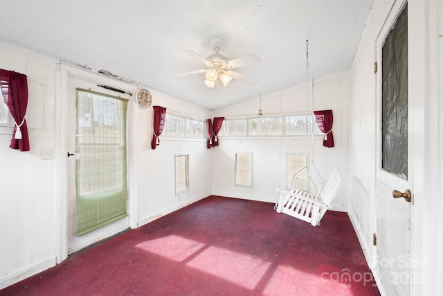 interior space with vaulted ceiling, ceiling fan, and dark carpet