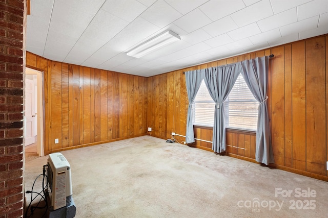 unfurnished room with light carpet and wood walls