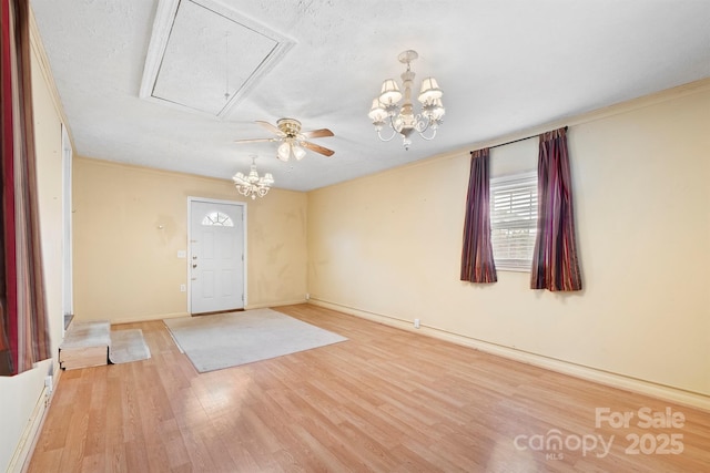 foyer with crown molding, a chandelier, light hardwood / wood-style flooring, and a textured ceiling