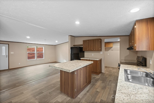 kitchen featuring sink, black fridge, a center island, electric range oven, and dark hardwood / wood-style floors