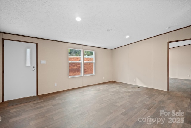 interior space with crown molding, a textured ceiling, and hardwood / wood-style flooring