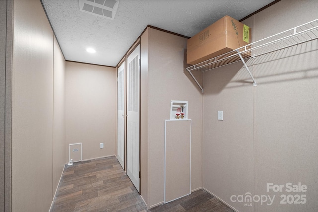 clothes washing area featuring hookup for a washing machine, a textured ceiling, and dark hardwood / wood-style flooring