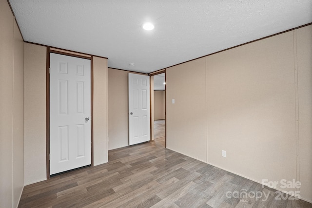 unfurnished bedroom featuring a textured ceiling and light wood-type flooring