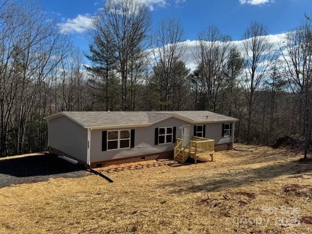 view of front facade featuring crawl space and a forest view