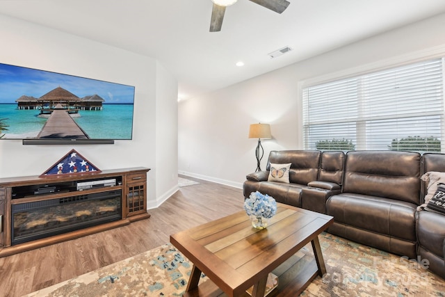 living room with ceiling fan and light wood-type flooring