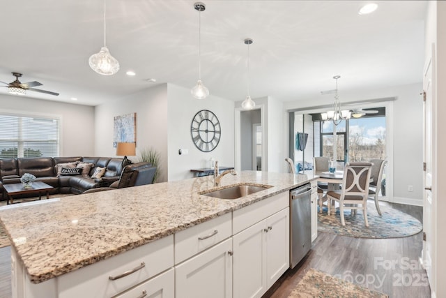 kitchen featuring a center island with sink, white cabinetry, pendant lighting, and stainless steel dishwasher