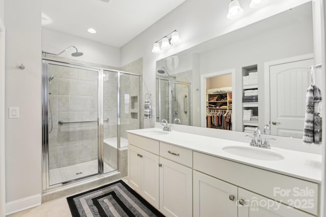 bathroom with tile patterned flooring, vanity, and walk in shower