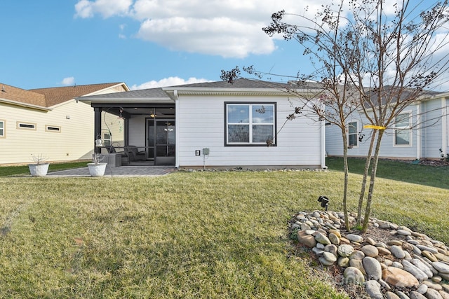 back of house featuring a sunroom, a patio area, and a lawn