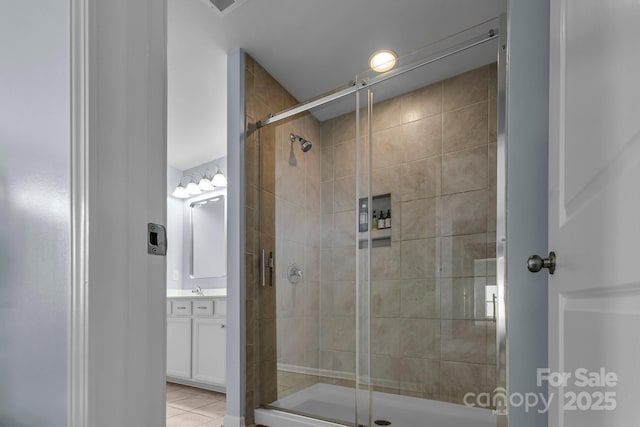 bathroom with tile patterned floors, vanity, and an enclosed shower