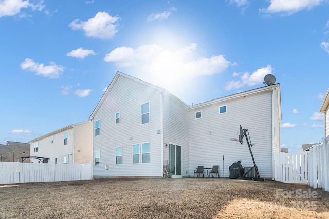 rear view of house featuring a yard