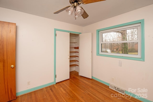 unfurnished bedroom with light hardwood / wood-style floors, a closet, and ceiling fan