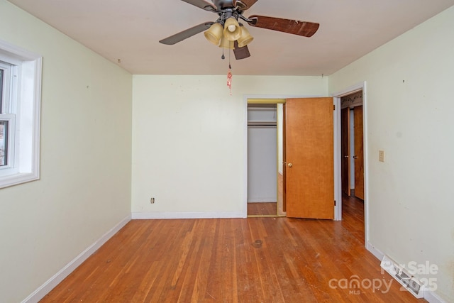 unfurnished bedroom featuring light wood-type flooring, ceiling fan, and a closet