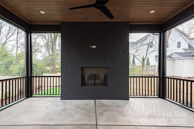 unfurnished sunroom with an outdoor brick fireplace, ceiling fan, and wood ceiling