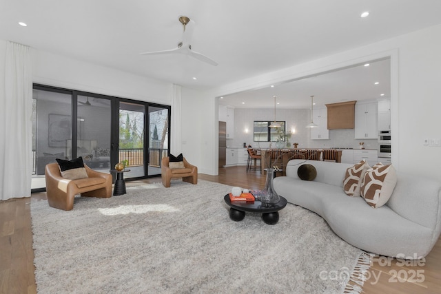 living room featuring hardwood / wood-style flooring and ceiling fan