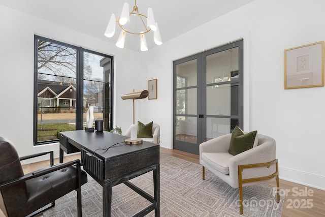 office space featuring an inviting chandelier, hardwood / wood-style flooring, and french doors