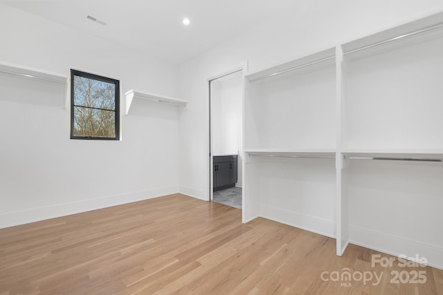 spacious closet with light hardwood / wood-style flooring