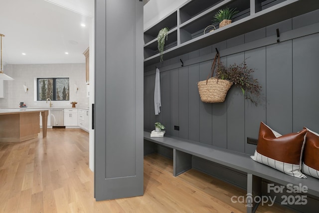 mudroom with sink and light hardwood / wood-style floors