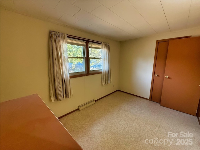 unfurnished bedroom featuring a baseboard heating unit