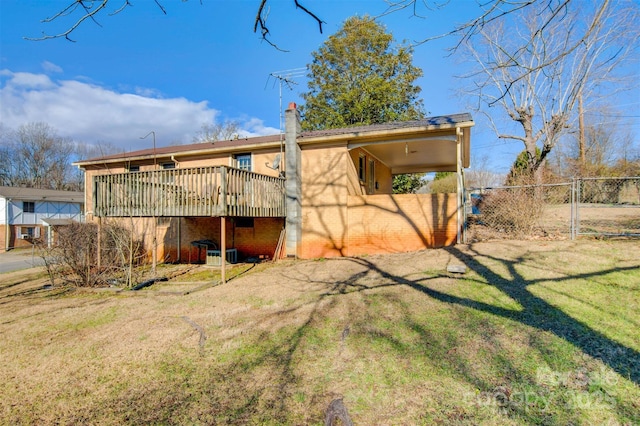 rear view of house featuring a yard and a deck