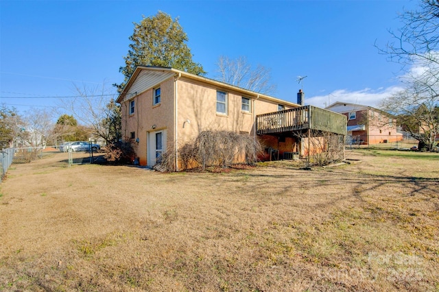 back of house with a wooden deck and a yard