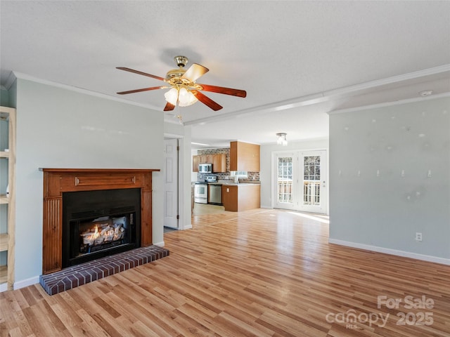 unfurnished living room with crown molding, ceiling fan, and light hardwood / wood-style flooring