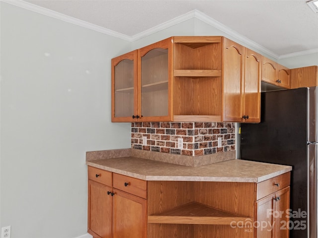 kitchen with stainless steel refrigerator, crown molding, and tasteful backsplash