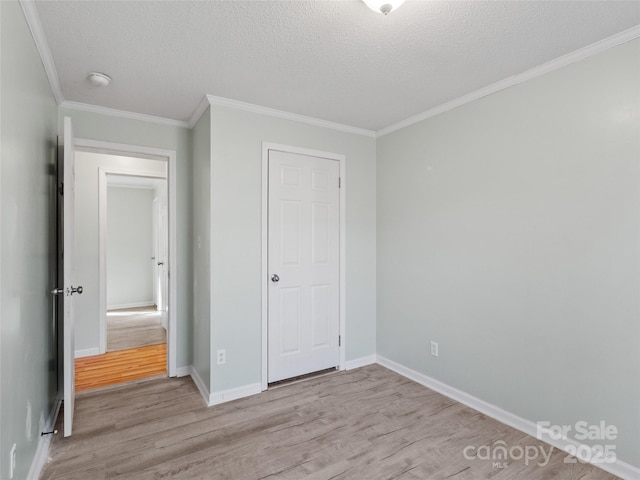 unfurnished bedroom with crown molding, a textured ceiling, and light hardwood / wood-style flooring