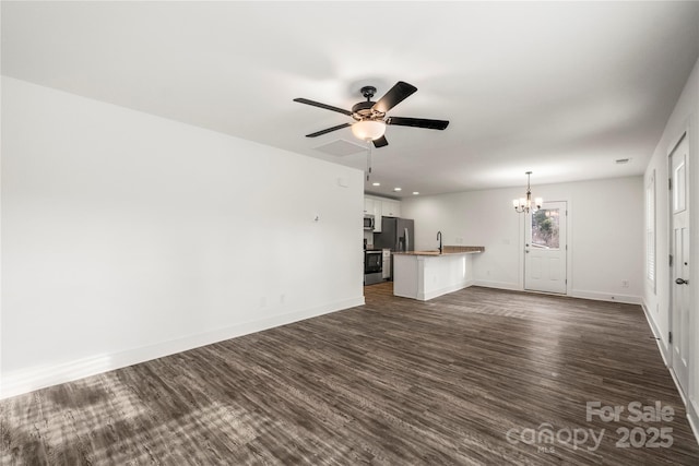 unfurnished living room featuring sink, ceiling fan with notable chandelier, and dark hardwood / wood-style floors