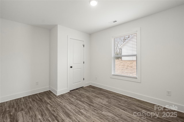 unfurnished room with dark hardwood / wood-style flooring