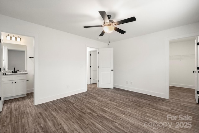 unfurnished bedroom with a walk in closet, dark wood-type flooring, and a closet