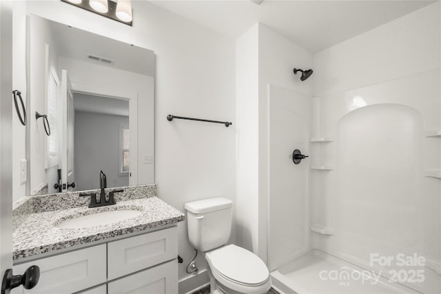 bathroom featuring walk in shower, vanity, and toilet