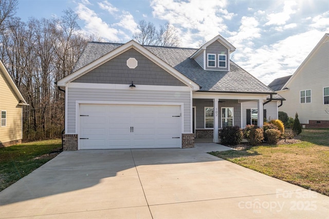 view of front facade with a garage, a front lawn, and covered porch