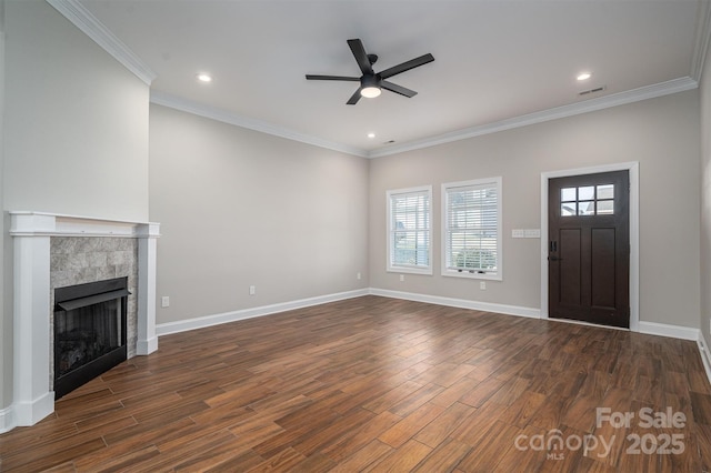 unfurnished living room with ornamental molding, a tile fireplace, dark hardwood / wood-style floors, and ceiling fan