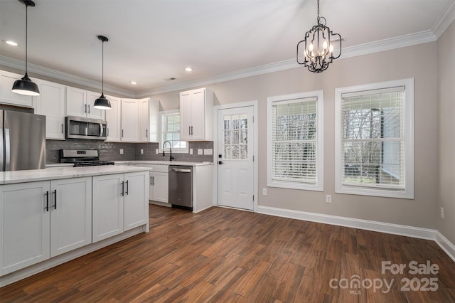 kitchen with hanging light fixtures, stainless steel appliances, light stone counters, white cabinets, and dark hardwood / wood-style flooring