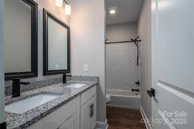 full bathroom featuring vanity, toilet, and tiled shower / bath