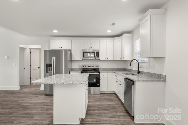 kitchen featuring white cabinetry, sink, stainless steel appliances, and a center island