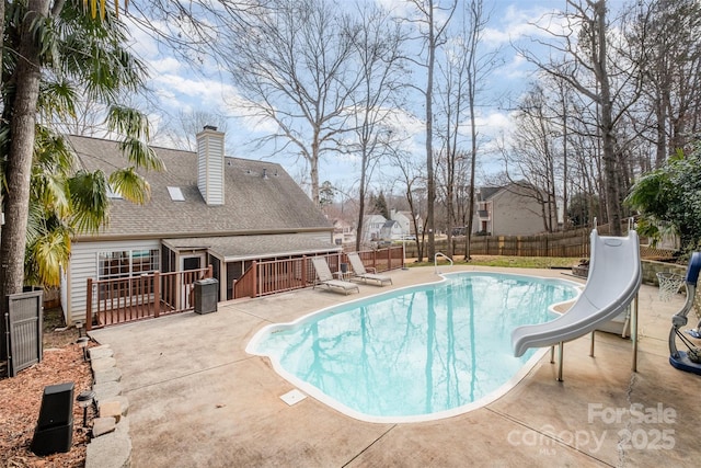 view of swimming pool with a patio and a water slide