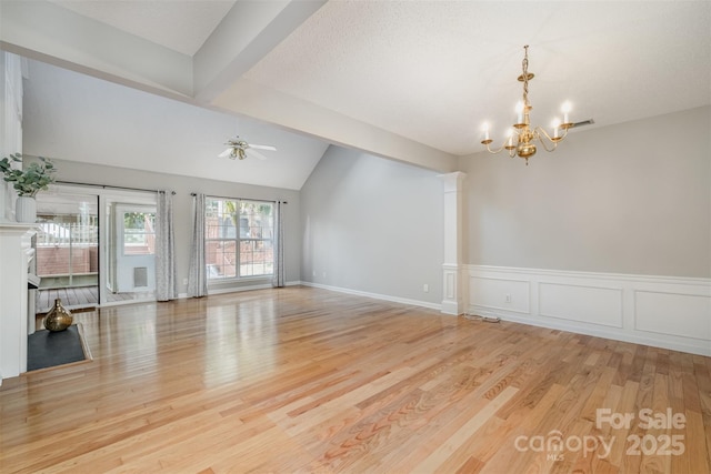 unfurnished room with ornate columns, vaulted ceiling, ceiling fan with notable chandelier, and light hardwood / wood-style floors