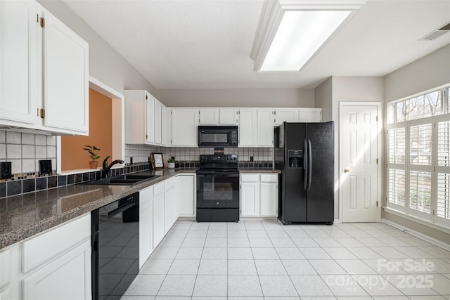 kitchen featuring white cabinetry, sink, black appliances, and dark stone counters