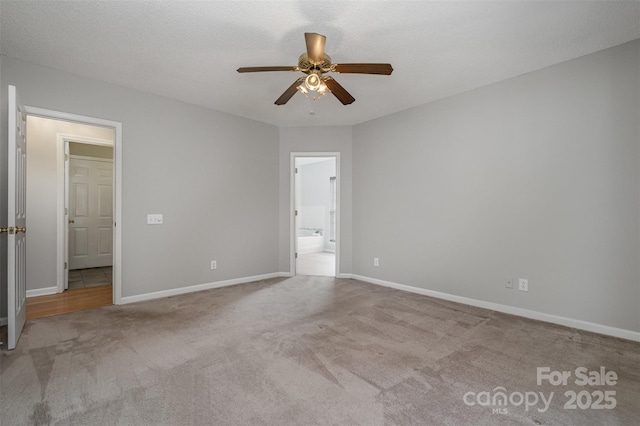 unfurnished bedroom featuring light carpet, connected bathroom, a textured ceiling, and ceiling fan