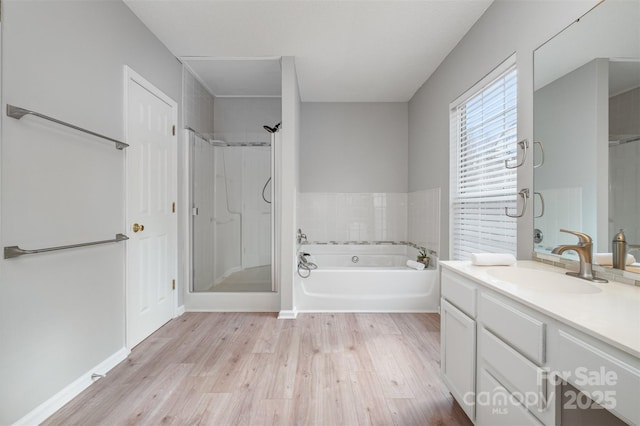 bathroom with hardwood / wood-style flooring, vanity, and shower with separate bathtub