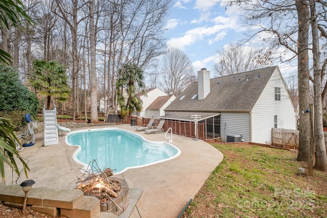 view of pool with an outdoor fire pit, a water slide, and a patio